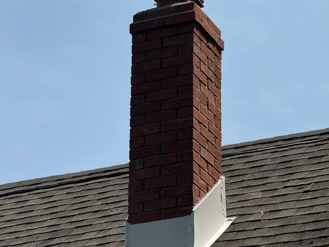Brick chimney with new metal base flashing and a new chimney cap fitted