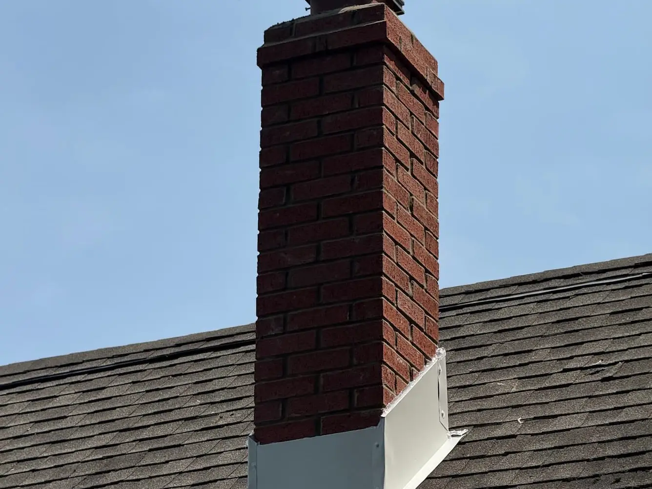 Brick chimney with new metal base flashing and a new chimney cap fitted