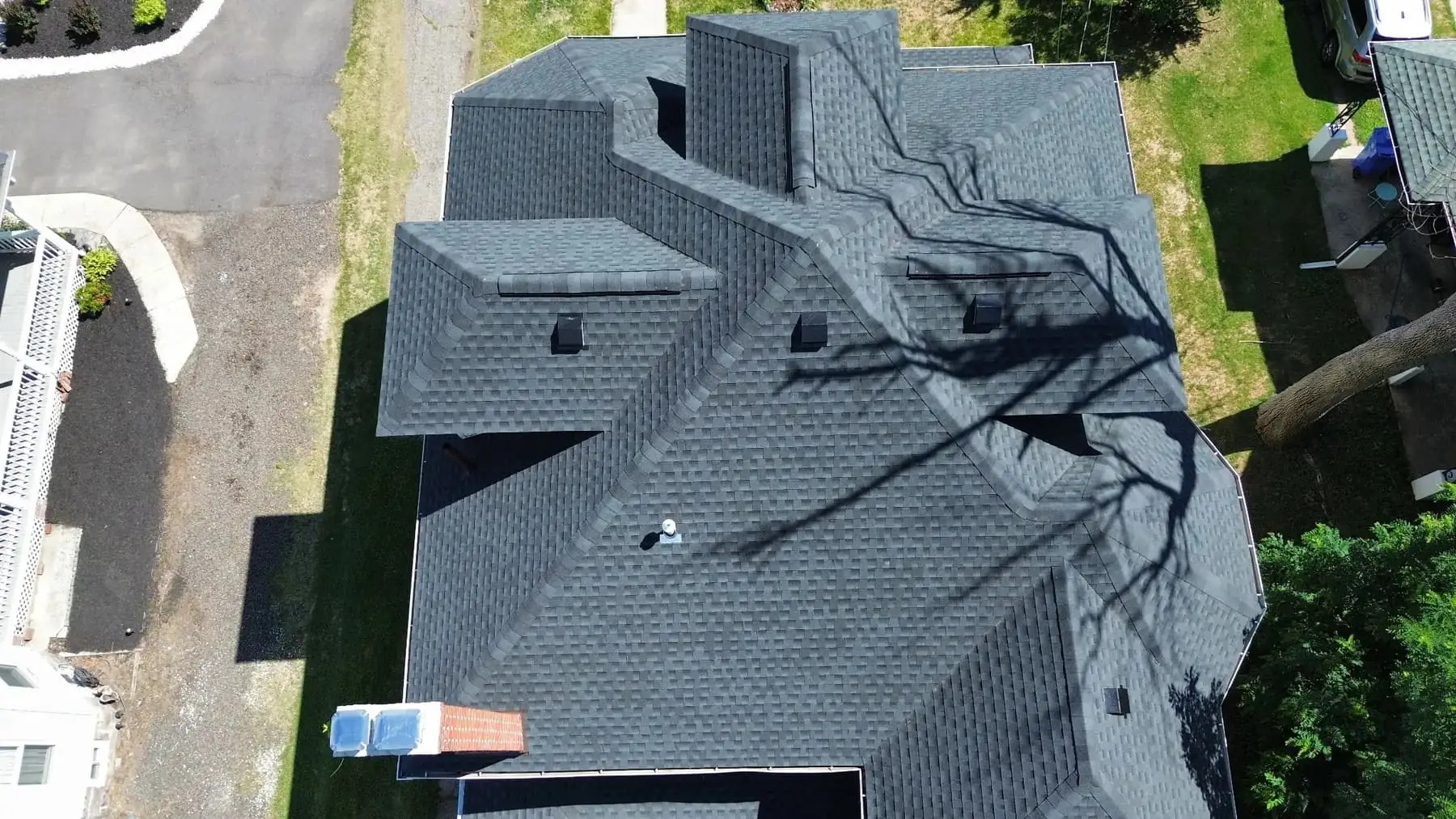 Aerial view of a completed architectural shingle roof on a two storey house