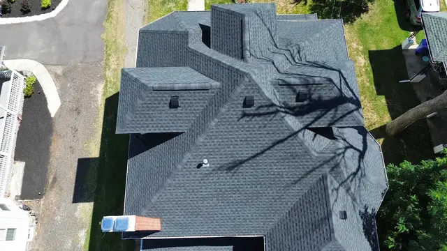 Aerial view of a completed architectural shingle roof on a two storey house
