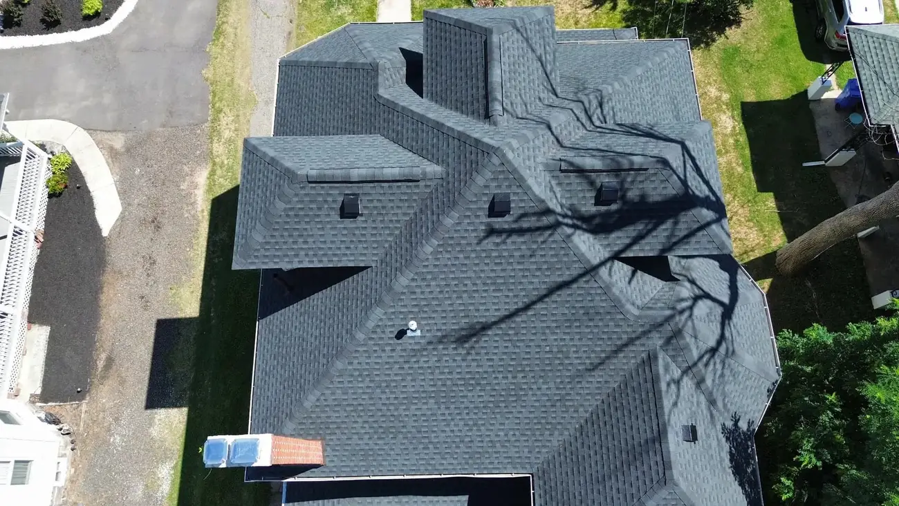 Aerial view of a completed architectural shingle roof on a two storey house